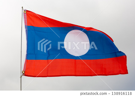 Flag of Laos flying against blue sky 138916118