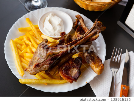 Grilled lamb ribs with french fries. Traditional spanish dish cordero ribs and patata Grilled lamb ribs with french fries. Traditional spanish dish cordero ribs and patata 138916125