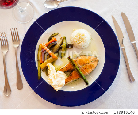 Baked salmon served with rice and vegetables Baked salmon served with rice and vegetables 138916146