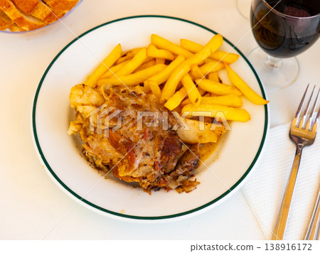 Braised pork knuckle served with garnish of crispy french fries Braised pork knuckle served with garnish of crispy french fries 138916172
