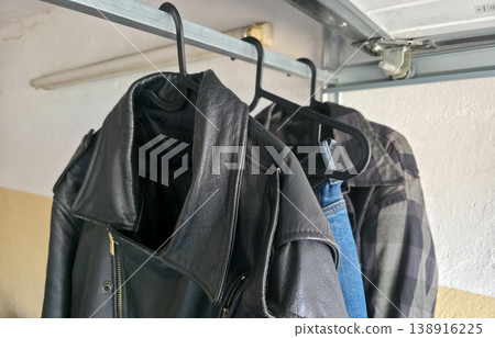 Men's motorcycle gear hangs on hangers in the garage. Stylish protective clothing for motorcycle riding. High quality photo 138916225