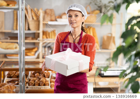 Portrait of female baker in apron with box Portrait of female baker in apron with box 138916669