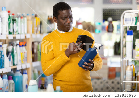 African man buyer scan QR code on packaging of spray in shop 138916689