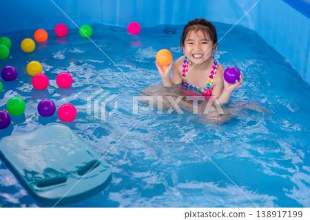 preschool child girl playing in swimming pool in backyard 138917199