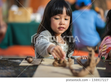 preschool child girl with sculpting from plasticine at outdoor park preschool child girl with sculpting from plasticine at outdoor park 138917227