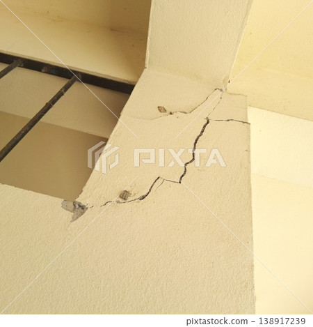Severe structural crack on concrete building column requiring urgent professional repair Severe structural crack on concrete building column requiring urgent professional repair 138917239