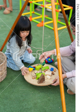 mother and preschool child girl playing with wooden toy block at outdoor mother and preschool child girl playing with wooden toy block at outdoor 138917442