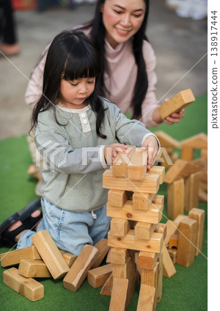 mother and preschool child girl playing with wooden toy block at outdoor mother and preschool child girl playing with wooden toy block at outdoor 138917444