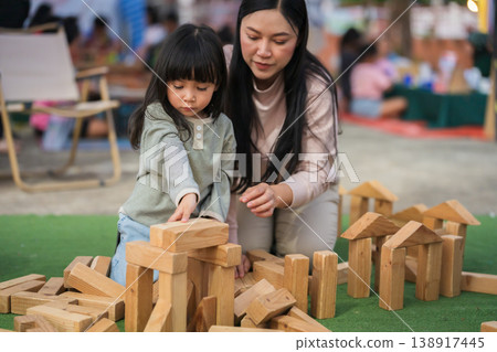 mother and preschool child girl playing with wooden toy block at outdoor 138917445