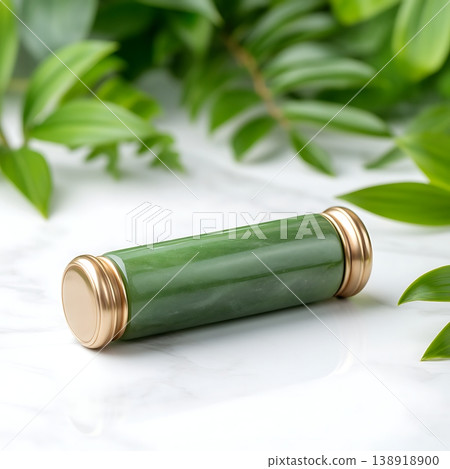 Elegant jade roller on a marble surface surrounded by lush green foliage and natural elements 138918900