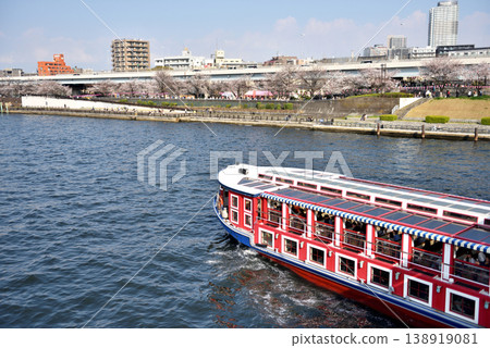 A cherry blossom viewing cruise ship sailing down the Sumida River 138919081