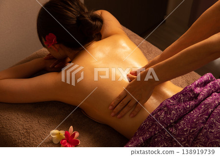 A woman receiving a massage in a relaxing space. 138919739