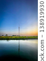 A Tranquil Reflection of a Communication Tower at Sunset, Bathing the Scene in Orange and Blue 138919930