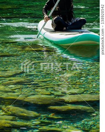 大自然中的水上運動：一位女士劃著立式槳板的特寫。 138920542