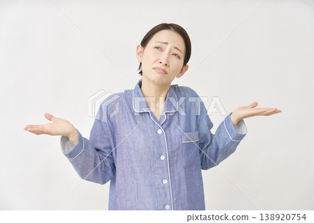 Woman in pajamas giving up gesture on white background 138920754