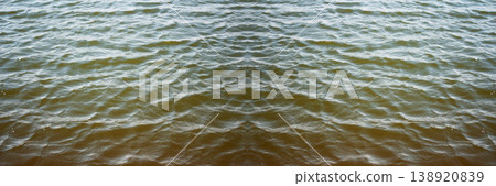 Water abstract banner background. Panoramic view of rippled water surface with symmetrical reflection. Dark murky river or lake water texture. aquatic background with small waves and copy space Water abstract banner background. Panoramic view of rippled water surface with symmetrical reflection. Dark murky river or lake water texture. aquatic background with small waves and copy space 138920839