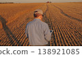 farmer working in wheat field, combine harvester ploughing in wheat field, agriculture tablet, connecting technology with nature, enhancing decision making with data, farming in the digital age, real 138921085