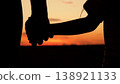 Warm sunset silhouette, child daughter safe between parents, father and mother holding hands, man woman people, little baby joy, outdoor nature landscape, sky glowing, childhood dream playtime 138921133