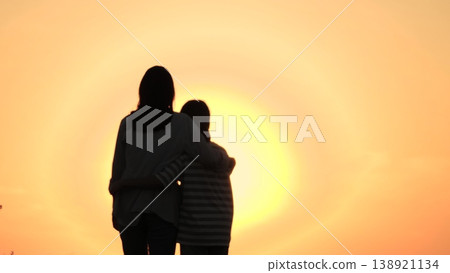 happy family,mother hugs holding child hand outdoors,parent girl child, Mother with child watching sunset, woman hugging kid silhouette, happy family connection in nature, childhood dream horizon happy family,mother hugs holding child hand outdoors,parent girl child, Mother with child watching sunset, woman hugging kid silhouette, happy family connection in nature, childhood dream horizon 138921134