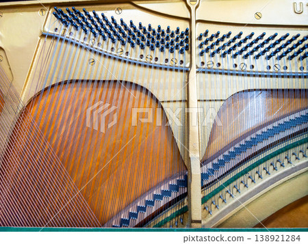 Disassembly of an upright piano: The strings are neatly stretched. 138921284