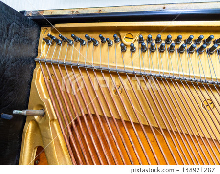 Disassembly of an upright piano: The strings are neatly stretched. 138921287