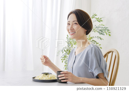 A woman eating Zaru Udon noodles in the living room A woman eating Zaru Udon noodles in the living room 138921329