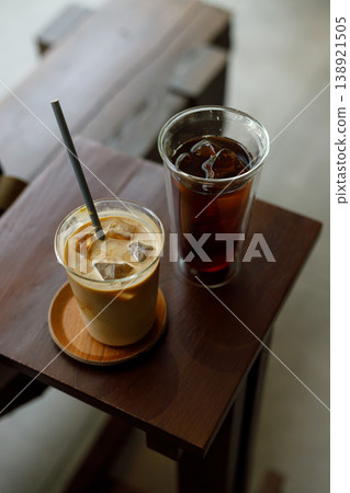Cups of iced milk latte coffee and iced black coffee on table by the window. Cups of iced milk latte coffee and iced black coffee on table by the window. 138921505