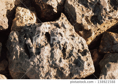 Rough natural porous stone surface texture forming a solid desert rock wall or landscape backdrop Rough natural porous stone surface texture forming a solid desert rock wall or landscape backdrop 138921588