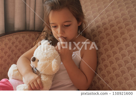 Pensive portrait: a young girl with a teddy bear, lost in quiet thought and contemplation Pensive portrait: a young girl with a teddy bear, lost in quiet thought and contemplation 138921600