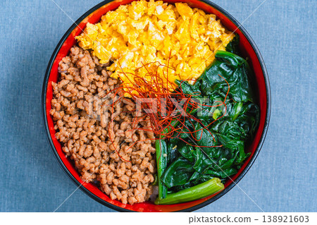 三色蓋飯:日式蓋飯,配上雞肉末、雞蛋和菠菜。 三色蓋飯:日式蓋飯,配上雞肉末、雞蛋和菠菜。 138921603