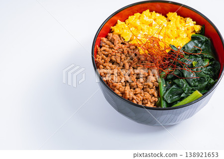 Three-color rice bowl: Japanese-style rice bowl with minced chicken, egg, and spinach. Three-color rice bowl: Japanese-style rice bowl with minced chicken, egg, and spinach. 138921653