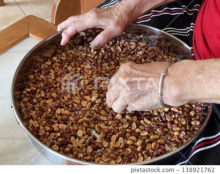 Close Up Of Hand Sorting Roasted Peanuts For Traditional Filling Preparation 138921762
