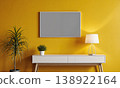 Mockup frame interior featuring blank canvas on mustard yellow wall above modern white console table with lamp 138922164