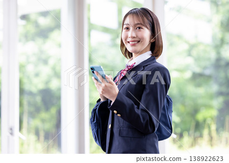 一名女高中生正在看她的智慧型手機。 一名女高中生正在看她的智慧型手機。 138922623