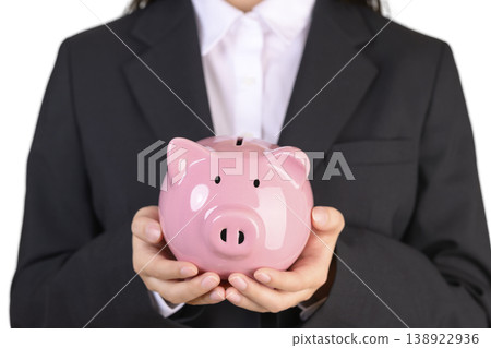 一位穿著西裝的女士拿著存錢罐 一位穿著西裝的女士拿著存錢罐 138922936