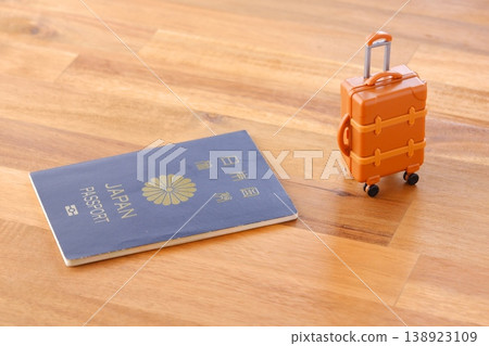 Passport and suitcase - An image of a person leaving for an overseas trip with a navy blue passport (for 5 years) and a suitcase. Passport and suitcase - An image of a person leaving for an overseas trip with a navy blue passport (for 5 years) and a suitcase. 138923109
