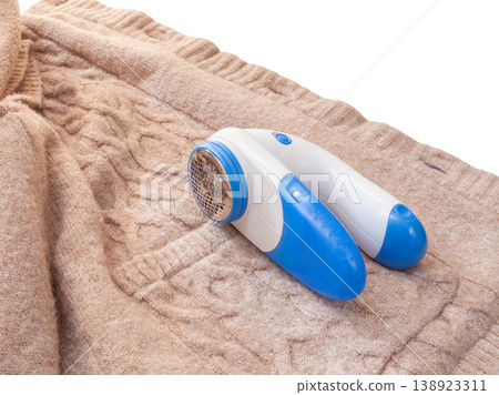 Removing pilling from wool clothing with a lint remover is a household chore for housewives. Removing pilling from wool clothing with a lint remover is a household chore for housewives. 138923311