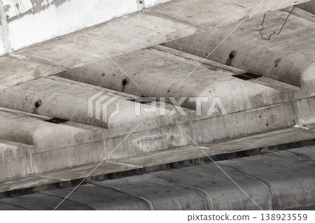 Underside of a weathered concrete bridge revealing reinforced beams 138923559