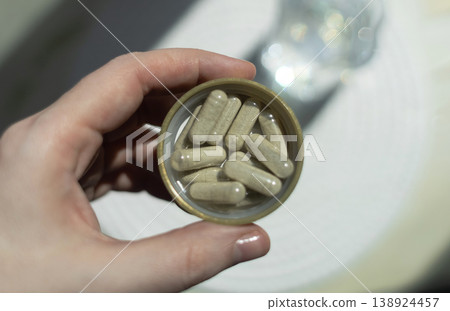 Close-up of iron supplement capsules in a lid for iron deficiency anemia treatment. Health care, wellness, and dietary supplements for daily vitamins and minerals intake. Close-up of iron supplement capsules in a lid for iron deficiency anemia treatment. Health care, wellness, and dietary supplements for daily vitamins and minerals intake. 138924457