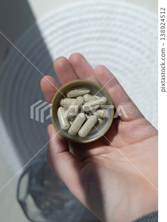 Close-up of iron supplement capsules in a lid for iron deficiency anemia treatment. Health care, wellness, and dietary supplements for daily vitamins and minerals intake. Close-up of iron supplement capsules in a lid for iron deficiency anemia treatment. Health care, wellness, and dietary supplements for daily vitamins and minerals intake. 138924512