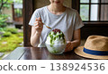 A summer tradition: A woman eating shaved ice in a traditional Japanese house, Uji Kintoki (matcha and red bean paste). 138924536
