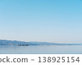 Mountains reflected on the tranquil surface of the lake, a waterside landscape woven from moonlight and islands. 138925154