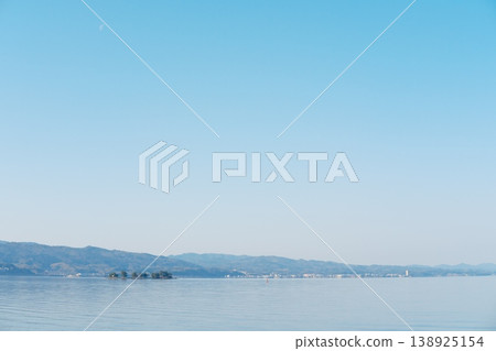 山脈倒映在寧靜的湖面上,月光與島嶼交織成一幅水鄉美景。 山脈倒映在寧靜的湖面上,月光與島嶼交織成一幅水鄉美景。 138925154