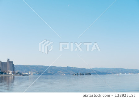 山脈倒映在寧靜的湖面上,月光與島嶼交織成一幅水鄉美景。 山脈倒映在寧靜的湖面上,月光與島嶼交織成一幅水鄉美景。 138925155
