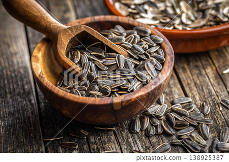 Sunflower Seeds in Wooden Bowls With Scoop on Rustic Tabletop. Snack and Healthy Seed Food 138925387