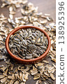 Sunflower Seeds in Bowl on Wooden Table With Scattered Shells Rustic Snack Background 138925396