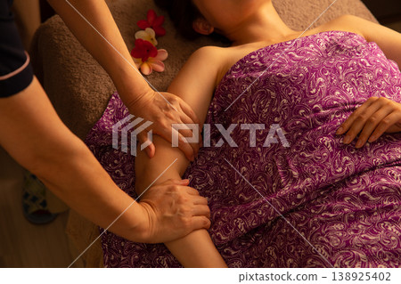 在峇裡島水療護理中，物理治療師的手握著顧客的手臂。 138925402