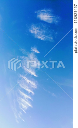 Delicate white wispy cirrus clouds forming a diagonal pattern against a vibrant clear blue sky. Delicate white wispy cirrus clouds forming a diagonal pattern against a vibrant clear blue sky. 138925467