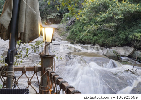 River with a lighted lamp post on the side 138925569