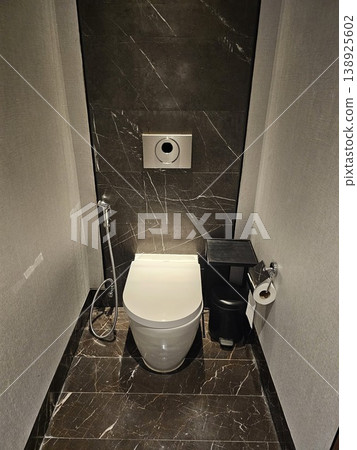 Small bathroom with a toilet and a trash can 138925602